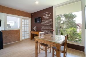 a dining room with a table and a menu on the wall at Casa Sabor Chocolate in Campos do Jordão