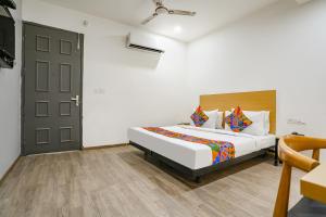 1 dormitorio con cama y puerta en FabHotel VAT - Meera Bagh en Nueva Delhi