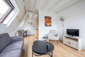 a living room with a couch and a tv at Appartementen Beatrix in De Koog