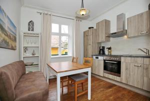 eine Küche mit einem Tisch, einem Sofa und einem Tisch in der Unterkunft Haus Glückauf Zum Strandläufer in Kühlungsborn