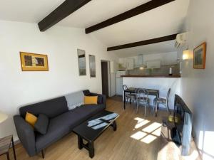 a living room with a couch and a table at Jolie petite maison Avignon - Montfavet in Montfavet