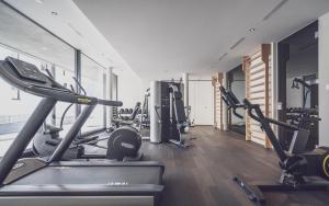 - une salle de sport avec plusieurs tapis de course et appareils de cardio-training dans l'établissement Parsenn Resort, à Davos