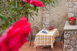 una mesa y sillas con una mesa y flores. en Antico Casale Ruoppo en SantʼAgata sui Due Golfi