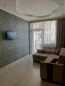 uma sala de estar com um sofá e uma televisão de ecrã plano em York Tower em Tbilisi
