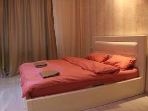 uma cama com lençóis laranja e almofadas laranja em York Tower em Tbilisi