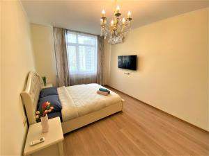 a small bedroom with a bed and a chandelier at FlatService Апартаменти в сучасному ЖК Parklend in Kyiv