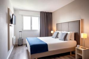 um quarto de hotel com uma cama e uma janela em Séjours & Affaires Paris Vincennes em Vincennes