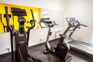a gym with three tread machines in a room at Séjours & Affaires Paris Vincennes in Vincennes