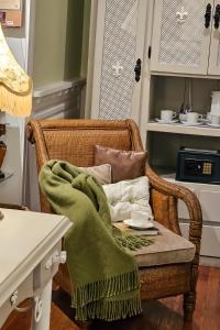 Villa Vicuña Hotel Boutique في سالتا: كرسي الخوص مع بطانية خضراء عليه