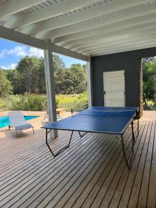 una mesa de ping pong azul en una terraza con piscina en Sporthaus.costaesmeralda en Pinamar