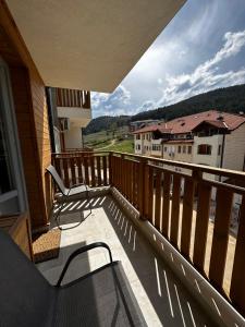 einen Balkon mit Stühlen und Blick auf ein Haus in der Unterkunft Апартамент НИА in Welingrad