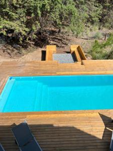 una piscina azul junto a una terraza de madera en Sporthaus.costaesmeralda en Pinamar