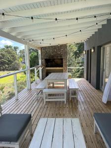 una terraza de madera con mesa y chimenea en Sporthaus.costaesmeralda en Pinamar