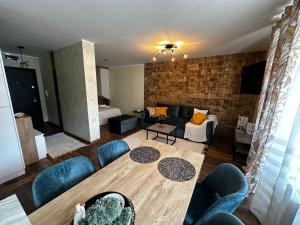 un soggiorno con tavolo e divano di Апартамент НИА a Velingrad