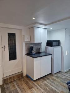 a small kitchen with a refrigerator and a microwave at Studio paisible CDG/Villepinte/Le Bourget in Aulnay-sous-Bois