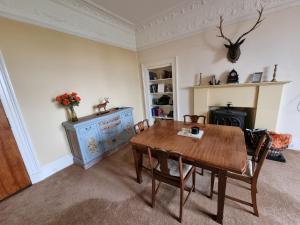 a dining room with a wooden table and chairs at Rowanbank House in Annan