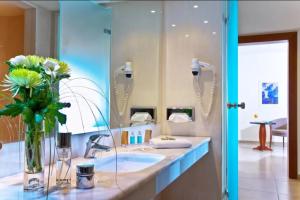 a bathroom with a sink and a mirror at Apollonia Beach Resort & Spa in Amoudara Herakliou