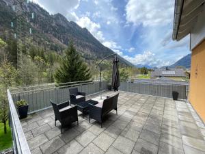 a patio with chairs and a table and an umbrella at homy Alpenlodge in Innerbraz
