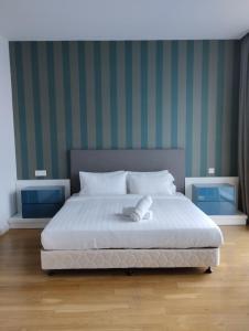a bedroom with a white bed with green striped walls at Amazing Pool By Platinum Suites KLCC in Kuala Lumpur