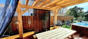 une terrasse avec une table en bois et une clôture dans l'établissement Les Bord'Océanes Sauna & Spa Villa Marensine et Villa Oyat, à Vielle-Saint-Girons