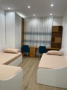 ein Krankenhauszimmer mit 2 Betten und einem Schreibtisch in der Unterkunft City Center Apartment Kafe Flora in Tirana