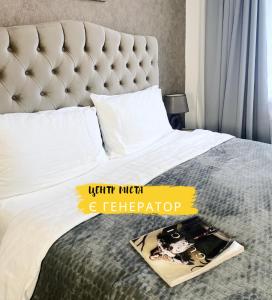 un libro che giace su un letto con una grande testiera di Venus Hotel Венус a Odessa
