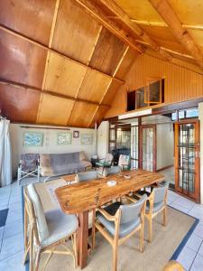 - un salon avec une table et des chaises en bois dans l'établissement LTB - A - Frame House, à Malgas