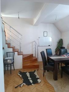 a living room with a table and chairs and a staircase at Vranje City Center, Penthouse Delux Apartment in Vranje