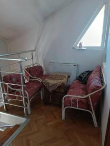 uma sala de estar com duas cadeiras e um sofá em Vranje City Center, Penthouse Delux Apartment em Vranje