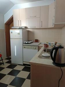 een keuken met witte apparatuur en een geruite vloer bij Vranje City Center, Penthouse Delux Apartment in Vranje