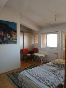 una camera con letto, tavolo e sedie di Vranje City Center, Penthouse Delux Apartment a Vranje