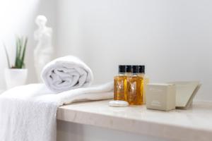 a bathroom counter with towels and essential oils on it at Palace Luxury Suites in Split