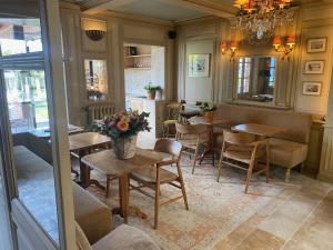 Un comedor con mesas y sillas y una lámpara de araña. en La Petite Lucie, en Honfleur