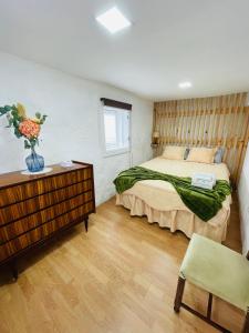 um quarto com uma cama e uma mesa com um vaso de flores em Casa de Ovil em Baião