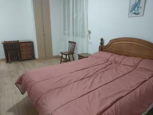 1 dormitorio con 1 cama grande y edredón rojo en Casa Rural Gerardo, en Armallones