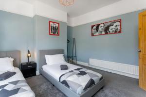 a bedroom with two beds and two pictures on the wall at Crawford Avenue Retreat in Liverpool