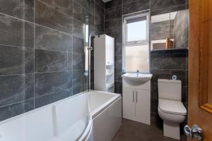 a bathroom with a toilet and a sink and a bath tub at Crawford Avenue Retreat in Liverpool