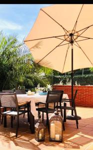 einen Tisch und Stühle mit Sonnenschirm auf einer Terrasse in der Unterkunft Apartamentos Costa Norte in San Vicente de la Barquera