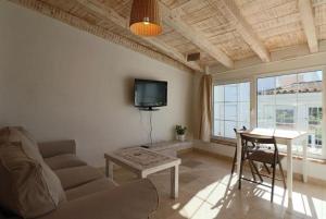 a living room with a couch and a table and a tv at Apartamentos Castillo Quince in Cartaya