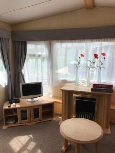 a living room with a desk with a computer and a window at Holiday Home Klavas in Sigulda