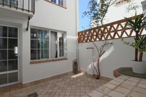 a villa with a gate and a patio at Apartamentos Castillo Quince in Cartaya