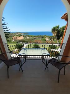 stół na balkonie z widokiem na ocean w obiekcie Mediterranean Studios w mieście Lassi