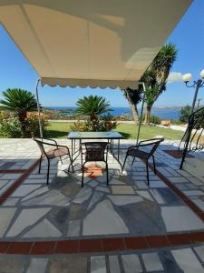 a patio with a table and chairs under a large umbrella at Mediterranean Studios in Lassi