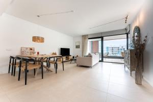 a dining room and living room with a table and chairs at Holiday apartment Middle Views in Fuengirola