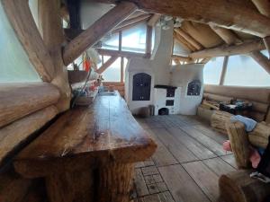 a large wooden table in a room with a fireplace at Mókus kulcsosház in Cîmpu Cetăţii