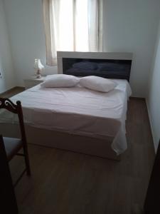 a bedroom with a large bed with white sheets and pillows at Acropolis view apartment in Limenas