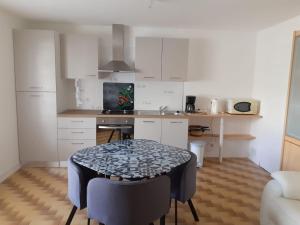 a kitchen with a table and a small kitchen with white cabinets at Mer campagne vignobles in Bretignolles-sur-Mer