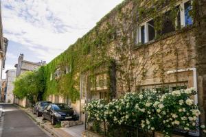 Un vieux bâtiment avec des fleurs sur son côté dans l'établissement La Petite Escale, à Avignon