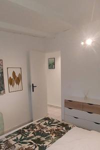 a white room with a bed and a wall at Le Ptit Gibs in Petit-Bourg