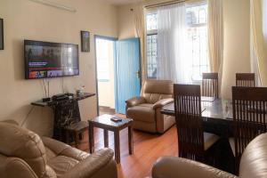 a living room with a couch and a tv at 2 bedroom entire Apt Fully air conditioned-MSA City centre in Mombasa